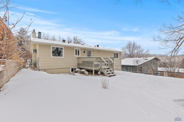 snow covered house featuring a deck