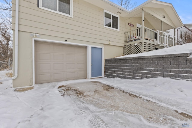 view of snow covered exterior with a garage