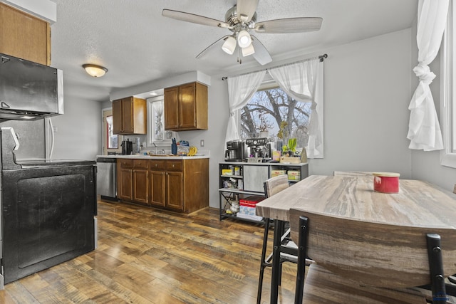 kitchen with range, a textured ceiling, stainless steel dishwasher, dark hardwood / wood-style floors, and ceiling fan