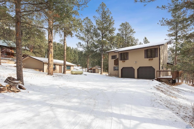 view of snow covered exterior with a garage and a deck