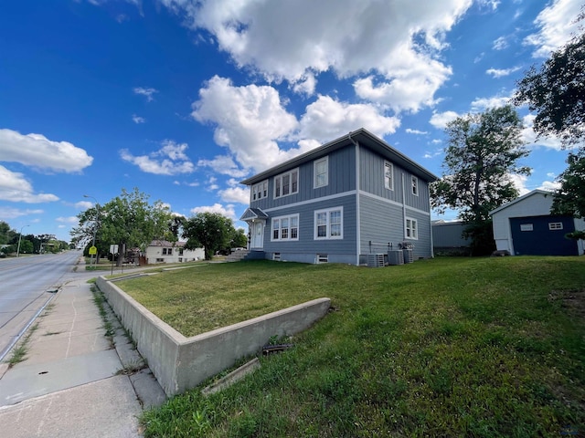 view of side of property with central air condition unit and a lawn