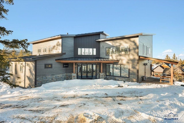 view of snow covered rear of property