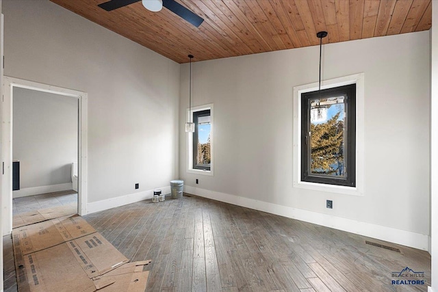 unfurnished room featuring dark wood-type flooring, lofted ceiling, and a healthy amount of sunlight