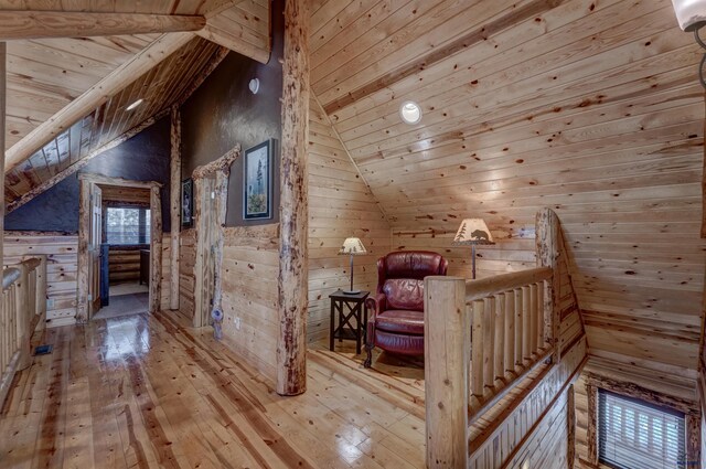 interior space featuring wood ceiling, light hardwood / wood-style flooring, lofted ceiling with beams, and wood walls