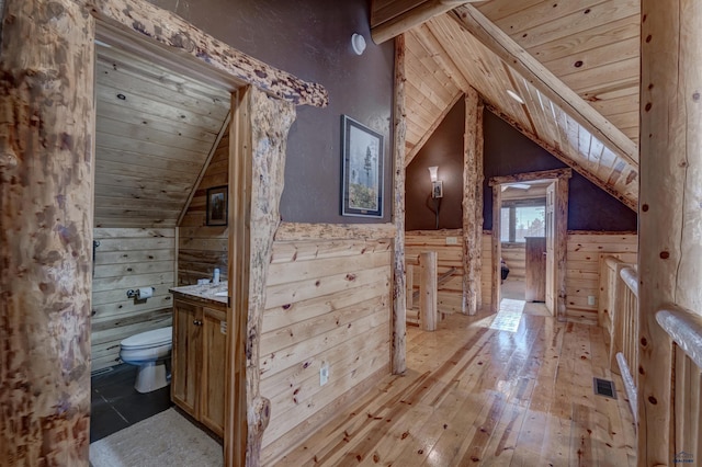 bathroom with toilet, wood walls, wood ceiling, wood-type flooring, and vanity