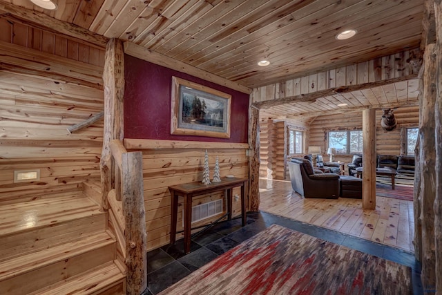 sitting room with dark wood-type flooring, wooden ceiling, and rustic walls