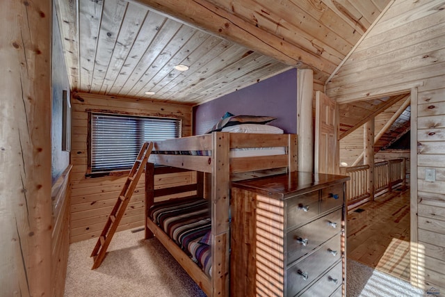 unfurnished bedroom featuring lofted ceiling, wood ceiling, light colored carpet, and wood walls