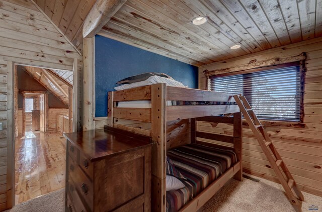 bedroom featuring lofted ceiling, wooden walls, light wood-type flooring, and wooden ceiling