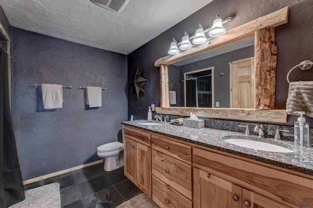 bathroom featuring vanity, a textured ceiling, tile patterned floors, and toilet
