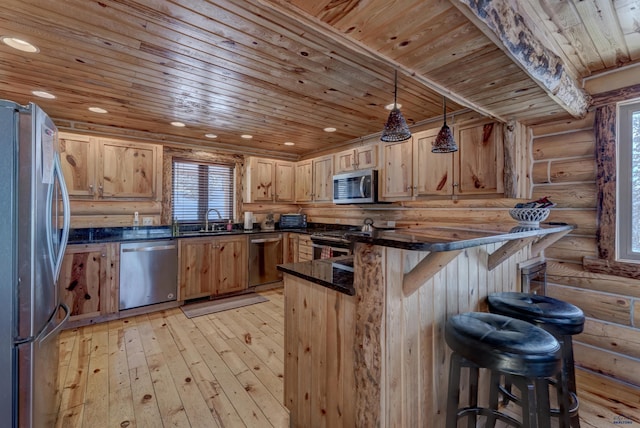 kitchen with sink, hanging light fixtures, wooden ceiling, appliances with stainless steel finishes, and a kitchen breakfast bar