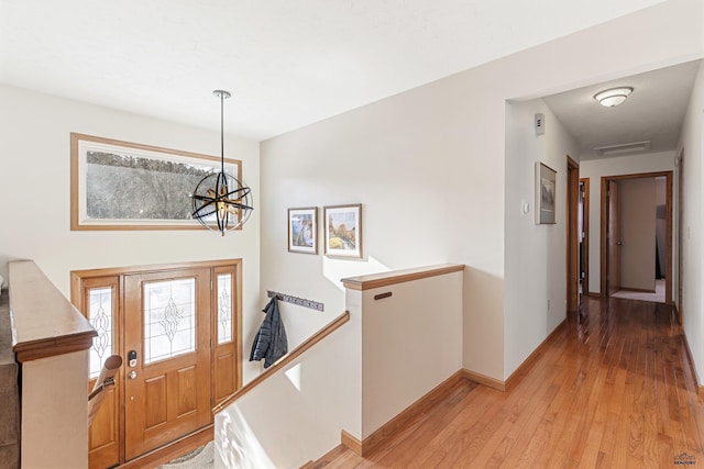 entryway with an inviting chandelier and light wood-type flooring