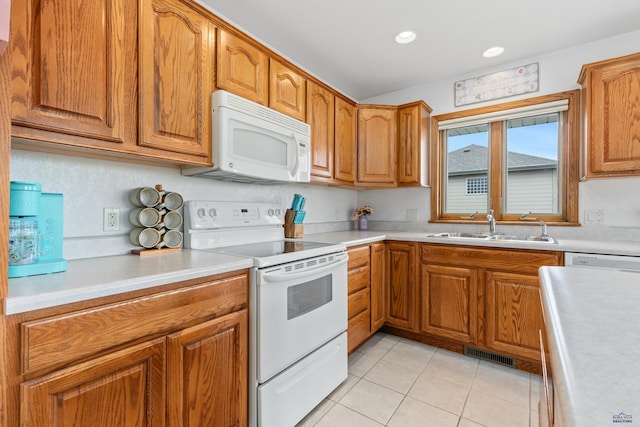 1021 Alta Vista Dr, Rapid City, SD 57701 - kitchen featuring white appliances, a sink, light tile patterned floors, brown cabinets, and recessed lighting