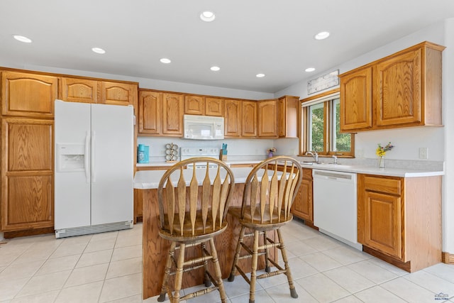 1021 Alta Vista Dr, Rapid City, SD 57701 - kitchen with white appliances, light countertops, recessed lighting, a kitchen island, and brown cabinets
