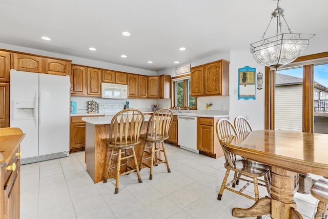 1021 Alta Vista Dr, Rapid City, SD 57701 - kitchen with white appliances, light countertops, brown cabinets, recessed lighting, and a chandelier