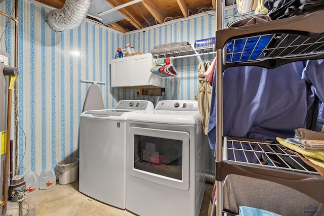 washroom featuring cabinets and washer and clothes dryer