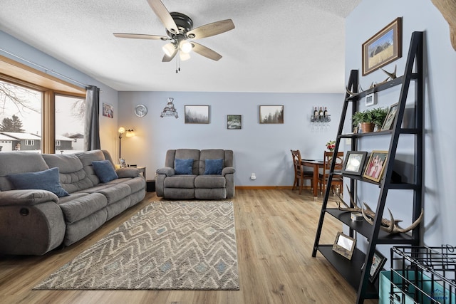 living room featuring hardwood / wood-style floors, a textured ceiling, and ceiling fan