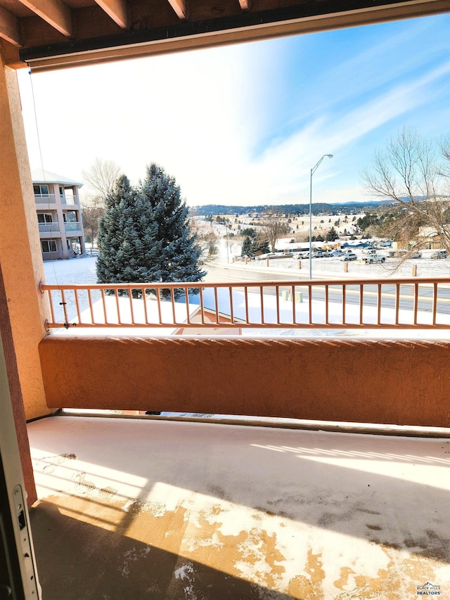 view of snow covered back of property