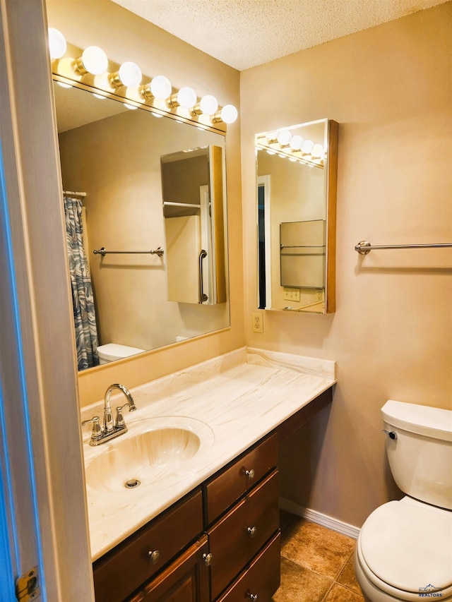 bathroom featuring vanity, tile patterned floors, toilet, and a textured ceiling