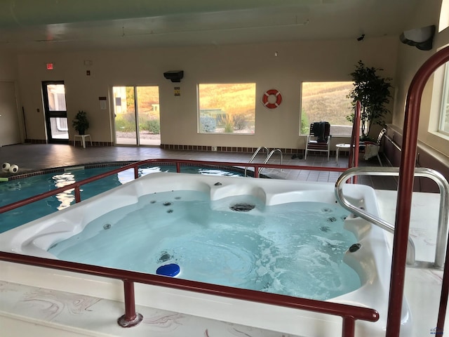 view of swimming pool with an indoor hot tub