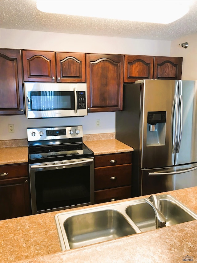 kitchen featuring sink, a textured ceiling, and appliances with stainless steel finishes