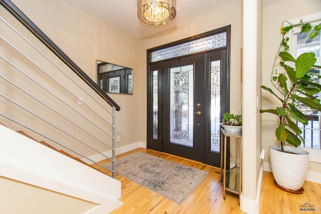 entryway featuring hardwood / wood-style flooring and a notable chandelier