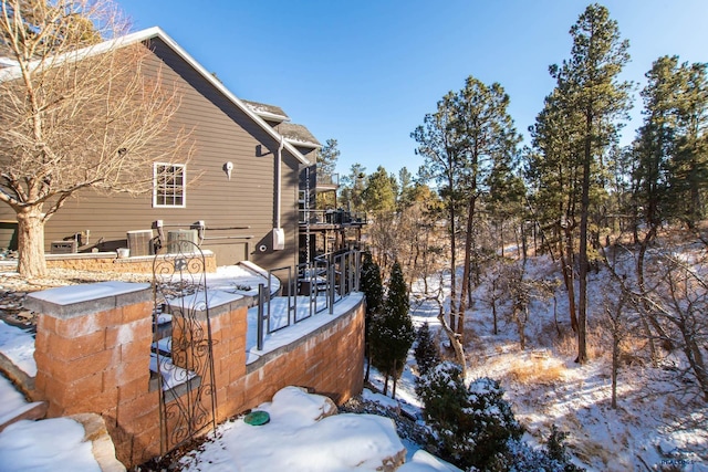 snow covered deck featuring cooling unit