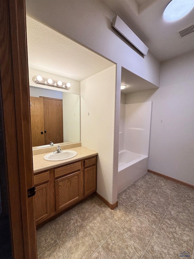 bathroom with vanity, bathing tub / shower combination, and a textured ceiling