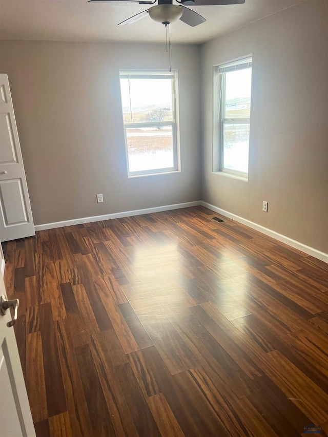 spare room with dark wood-type flooring and ceiling fan