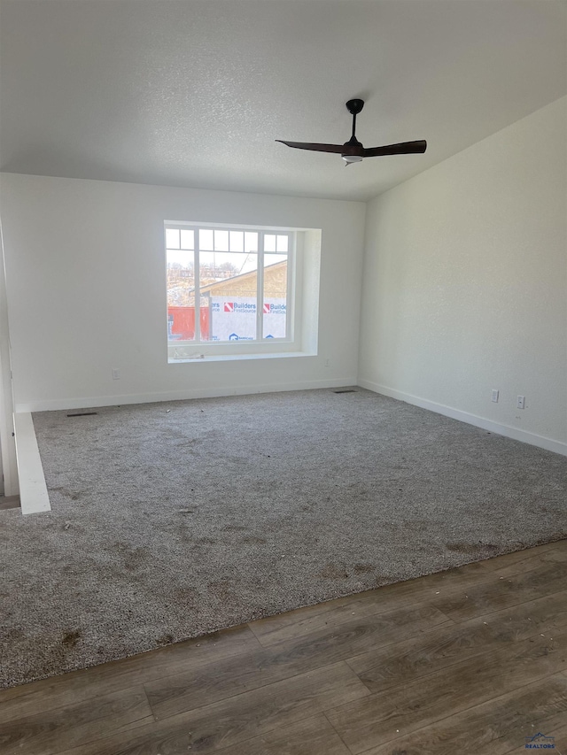 empty room with wood-type flooring, ceiling fan, and a textured ceiling