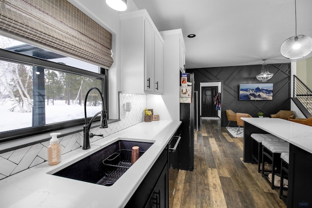 kitchen featuring hanging light fixtures, white cabinetry, sink, and dark wood-type flooring