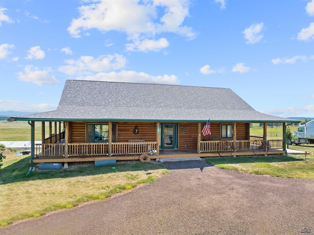 log home with a porch and a front lawn