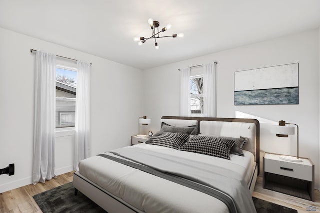 bedroom featuring a notable chandelier and light wood-type flooring