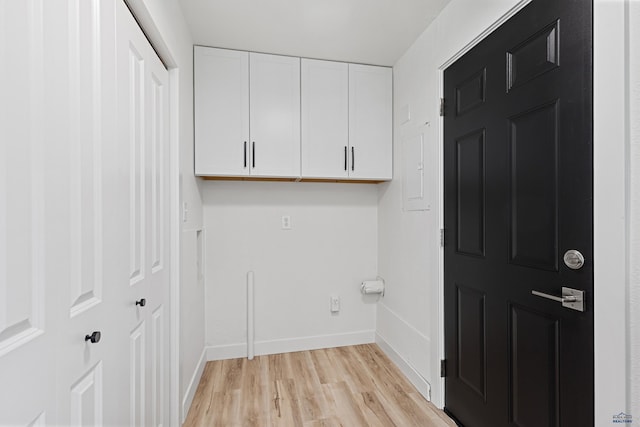 laundry area featuring cabinets and light hardwood / wood-style flooring