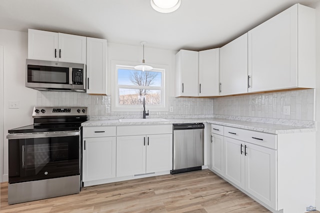 kitchen featuring appliances with stainless steel finishes, sink, and white cabinets