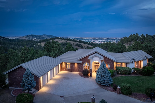 ranch-style house featuring a mountain view, a garage, and a lawn