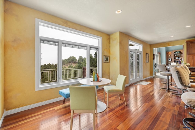 dining space with hardwood / wood-style flooring, french doors, and built in shelves