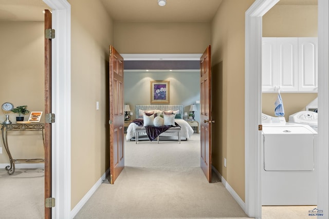 corridor featuring light carpet and washer and clothes dryer