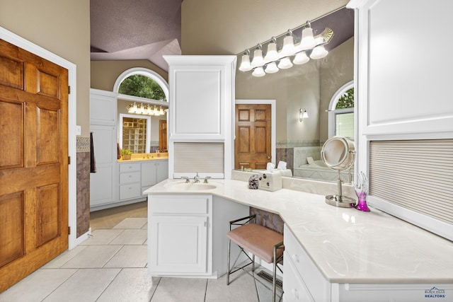 bathroom featuring tile patterned flooring, vanity, vaulted ceiling, and a textured ceiling