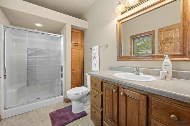 bathroom with vanity, toilet, and a shower with shower door