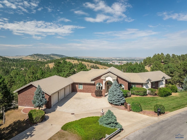 ranch-style house featuring a mountain view, a garage, and a front yard