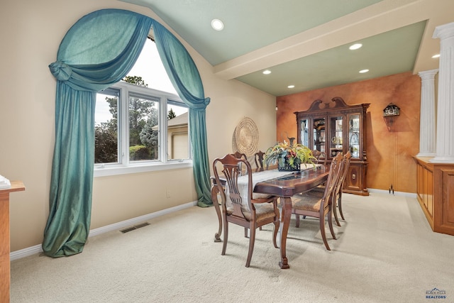 dining area with vaulted ceiling, light colored carpet, and decorative columns