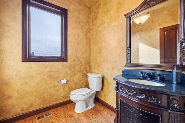 bathroom with hardwood / wood-style flooring, vanity, and toilet