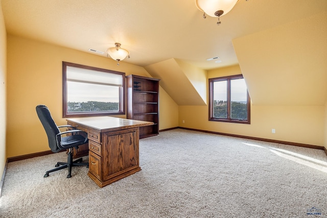 carpeted home office with lofted ceiling