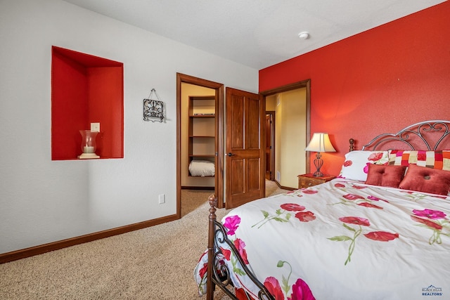 carpeted bedroom featuring a walk in closet