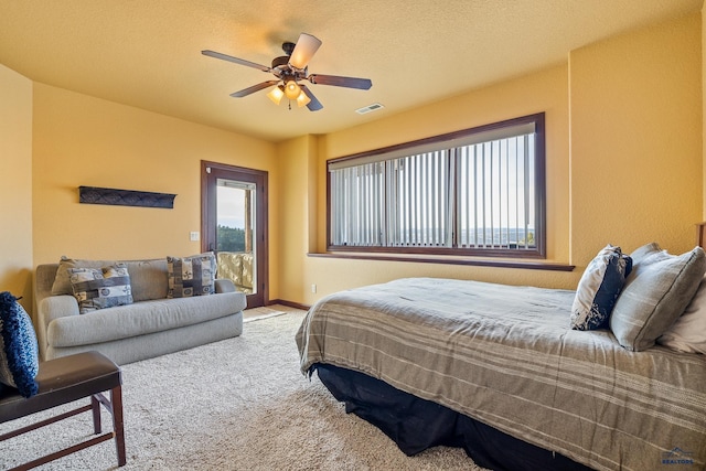 bedroom featuring light colored carpet, a textured ceiling, and ceiling fan