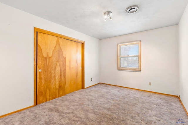 unfurnished bedroom featuring carpet flooring and a closet