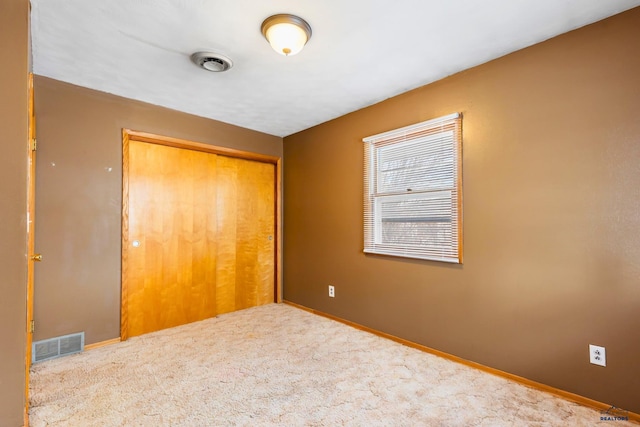 unfurnished bedroom with carpet flooring and a closet