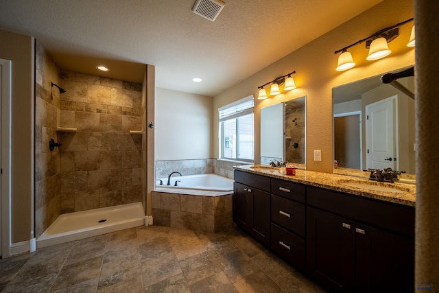 bathroom with a textured ceiling, plus walk in shower, and vanity