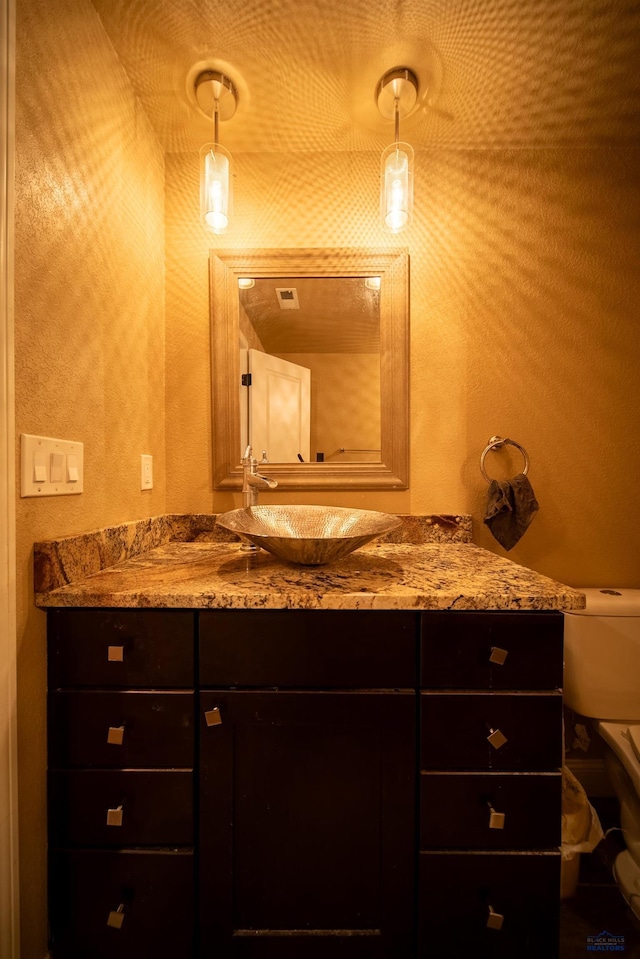 bathroom featuring vanity and toilet