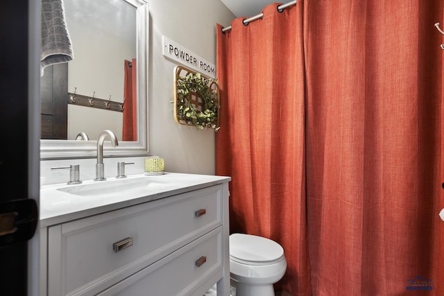 bathroom with curtained shower, vanity, and toilet